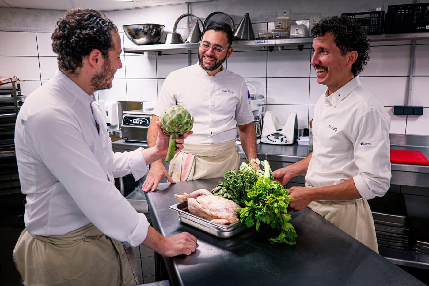 Trois cuisiniers en cuisine, en train de préparer un service