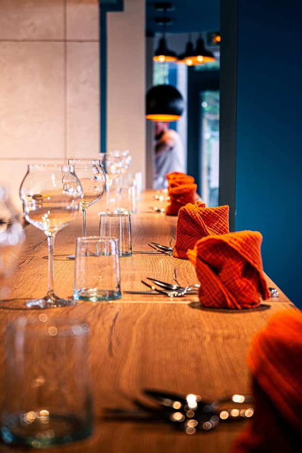 Une table dressée avec verres à vin et serviette rouge